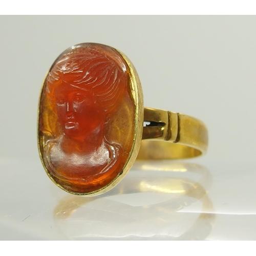 718 - A bright yellow metal ring set with a carved carnelian intaglio