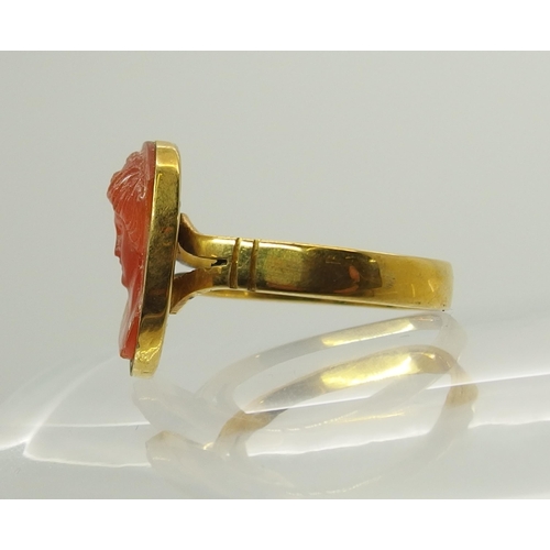 718 - A bright yellow metal ring set with a carved carnelian intaglio