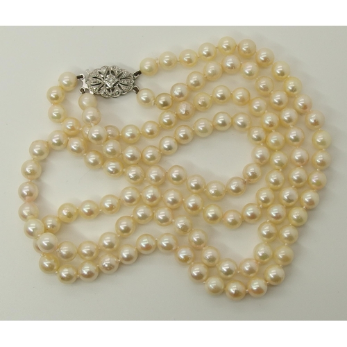 725 - A double string of baroque pearls with a 9ct diamond set clasp