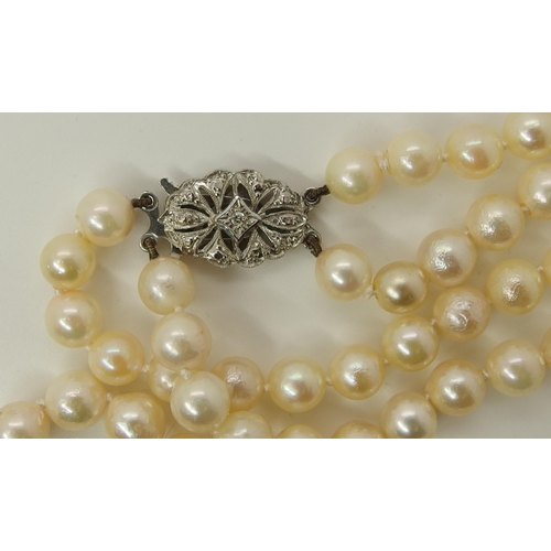 725 - A double string of baroque pearls with a 9ct diamond set clasp