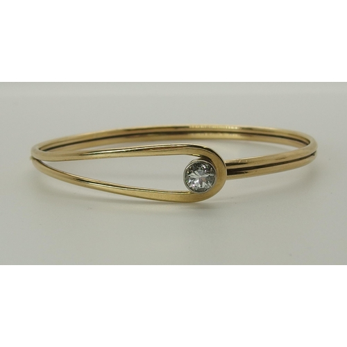 731 - A 9ct gold hand made bangle set with a diamond