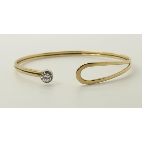 731 - A 9ct gold hand made bangle set with a diamond