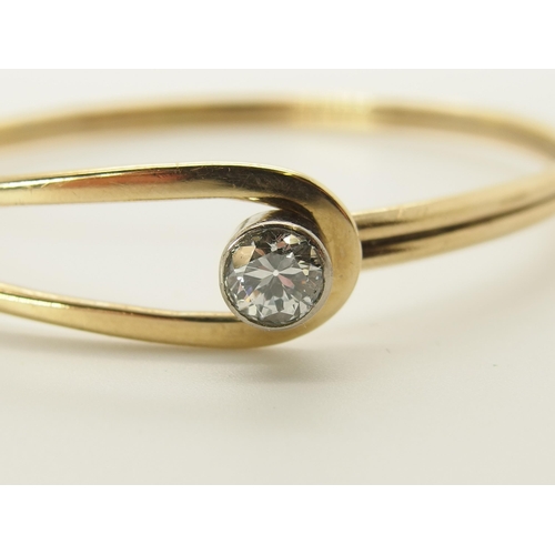 731 - A 9ct gold hand made bangle set with a diamond