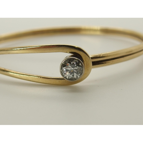 731 - A 9ct gold hand made bangle set with a diamond