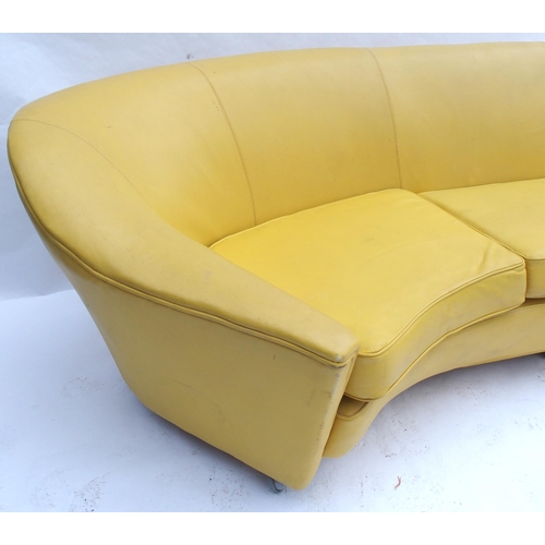 899 - A 1960's yellow leather crescent shaped three seater sofa