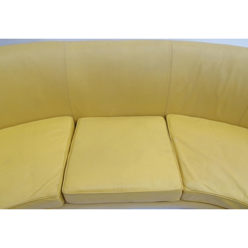 899 - A 1960's yellow leather crescent shaped three seater sofa