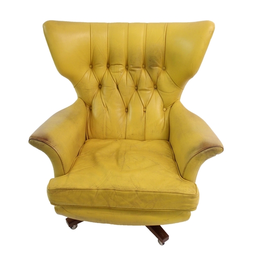 900 - A 1960's yellow leather button back swivel rocker