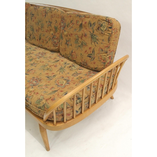 909 - A light Ercol daybed with floral cushions