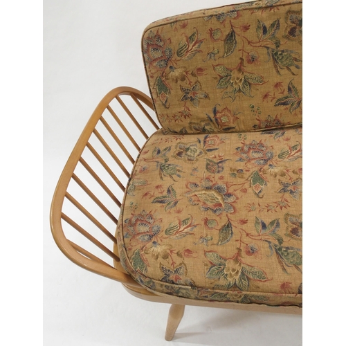 909 - A light Ercol daybed with floral cushions