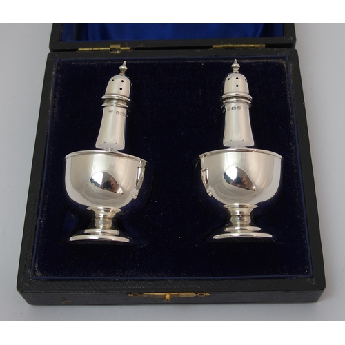 203 - A cased pair of silver pepperettes