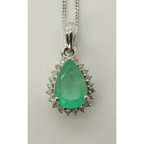 723 - A 9ct white gold emerald and diamond pendant