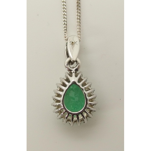 723 - A 9ct white gold emerald and diamond pendant