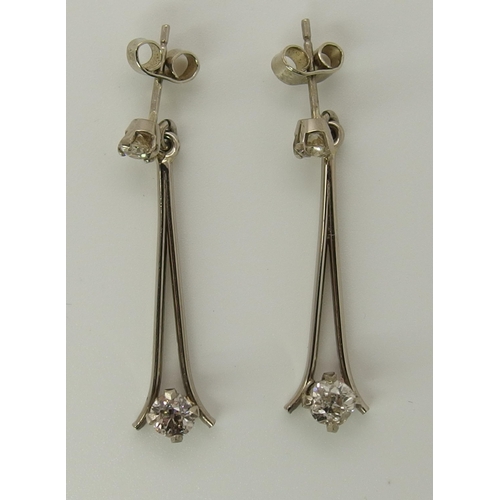 751 - A pair of white metal diamond drop earrings