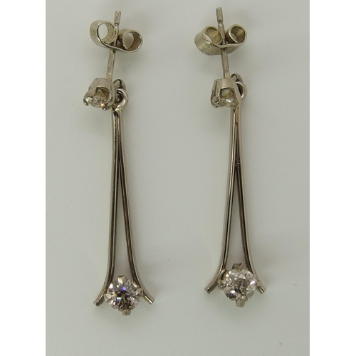 751 - A pair of white metal diamond drop earrings