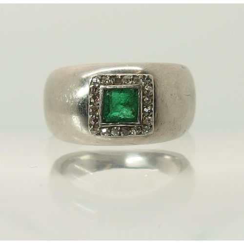 765 - A white metal emerald and diamond ring