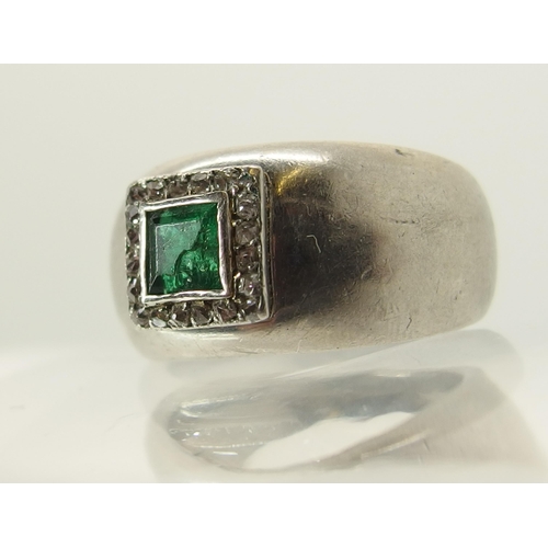 765 - A white metal emerald and diamond ring