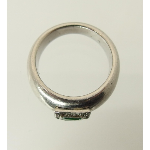 765 - A white metal emerald and diamond ring