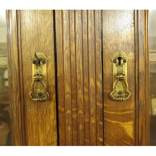 819 - An Edwardian oak three door bookcase