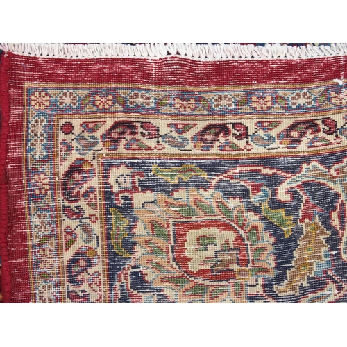 891 - A red ground meshed rug