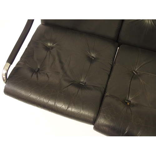 917A - A black leather and chrome Pirelli three seater sofa