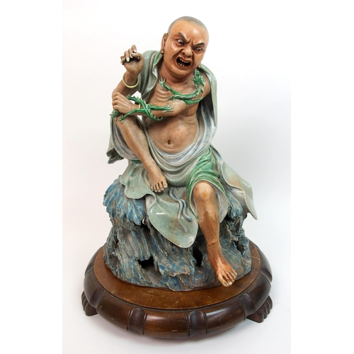 23 - A Chinese ceramic sculpture of a Taoist monk and serpent