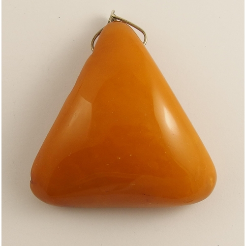 657 - A triangular shaped imperial yellow amber coloured pendant