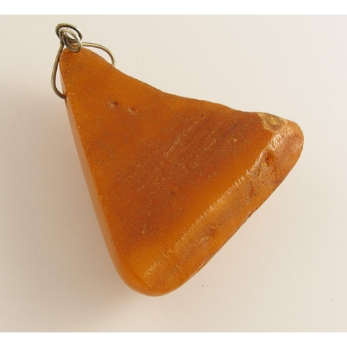 657 - A triangular shaped imperial yellow amber coloured pendant