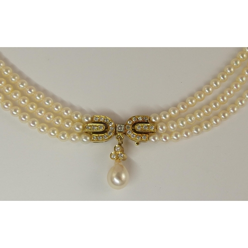 695 - A triple string of pearls with a diamond clasp