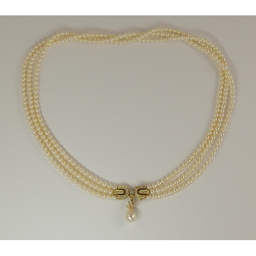 695 - A triple string of pearls with a diamond clasp