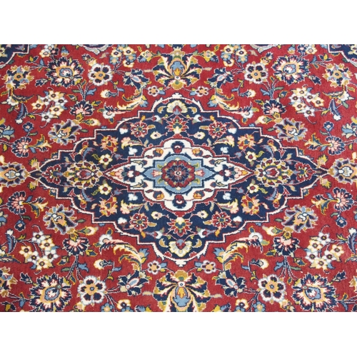 866 - A red ground and woven Persian Kashan rug