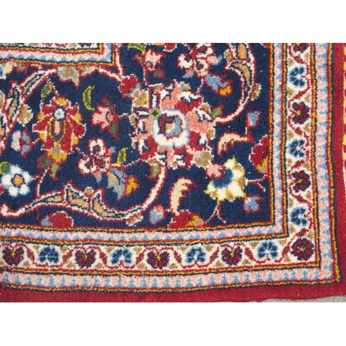 866 - A red ground and woven Persian Kashan rug