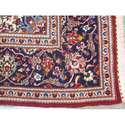 866 - A red ground and woven Persian Kashan rug