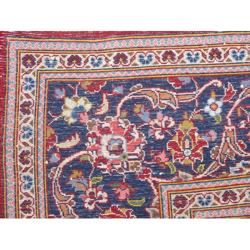 866 - A red ground and woven Persian Kashan rug