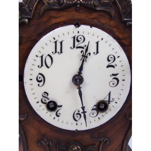 552 - A late 19th century / early 20th century walnut mantle clock