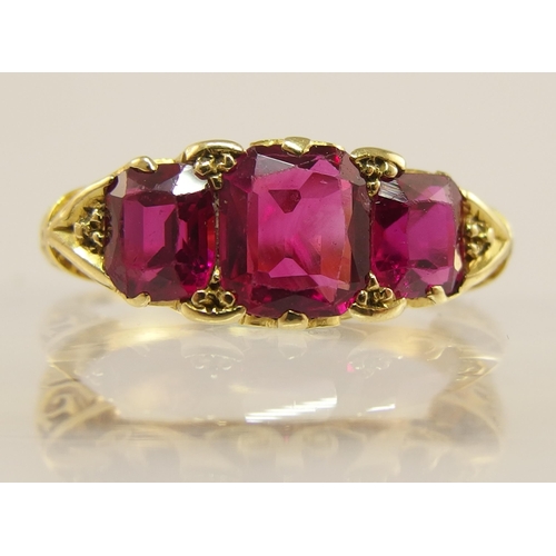 620 - An 18ct gold three stone ruby ring