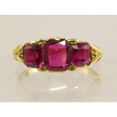 620 - An 18ct gold three stone ruby ring