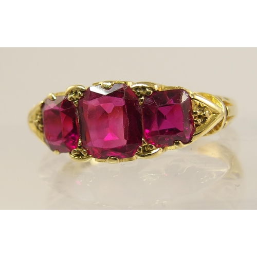 620 - An 18ct gold three stone ruby ring