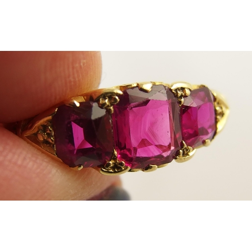 620 - An 18ct gold three stone ruby ring