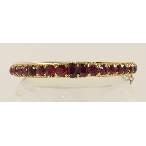 654 - A graduated oval mixed cut ruby set bangle