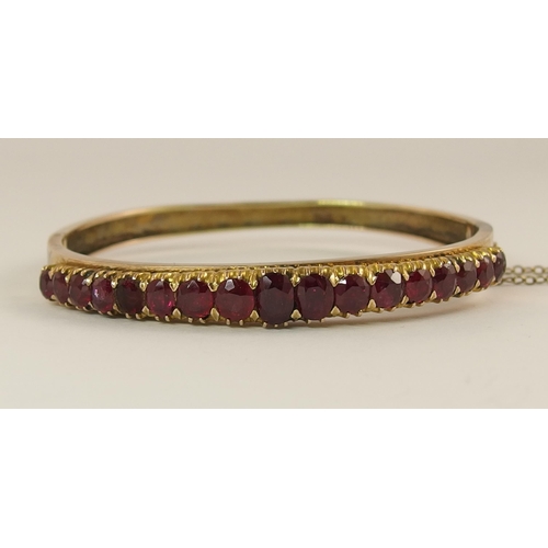 654 - A graduated oval mixed cut ruby set bangle