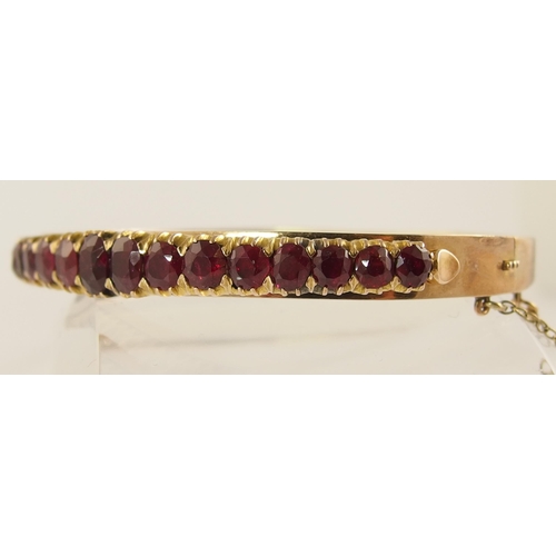 654 - A graduated oval mixed cut ruby set bangle