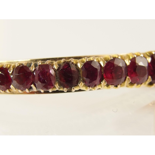 654 - A graduated oval mixed cut ruby set bangle