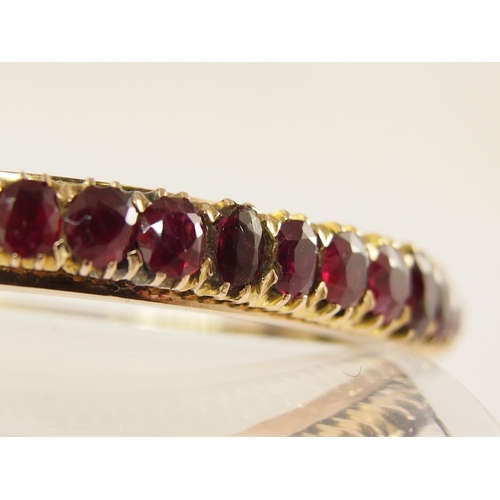 654 - A graduated oval mixed cut ruby set bangle