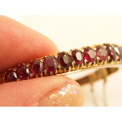 654 - A graduated oval mixed cut ruby set bangle