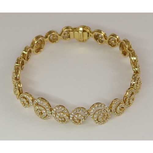 655 - An 18ct gold diamond bracelet of spiral forms