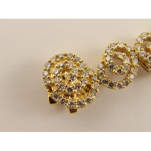 655 - An 18ct gold diamond bracelet of spiral forms