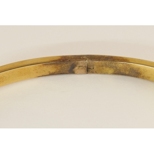 737 - An Etruscan revival bangle set with diamonds and a red gem