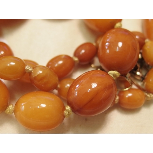 748 - Two amber coloured bead necklaces and a pair of earrings