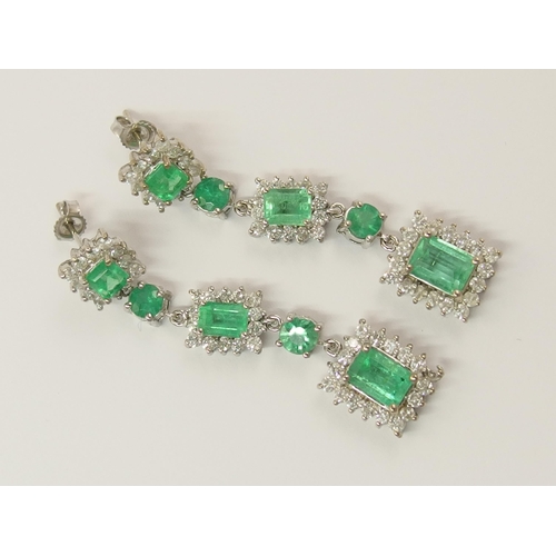 778 - A pair of long dangly diamond and emerald earrings