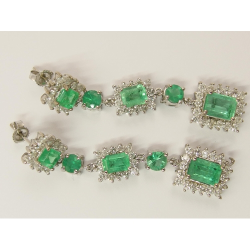 778 - A pair of long dangly diamond and emerald earrings